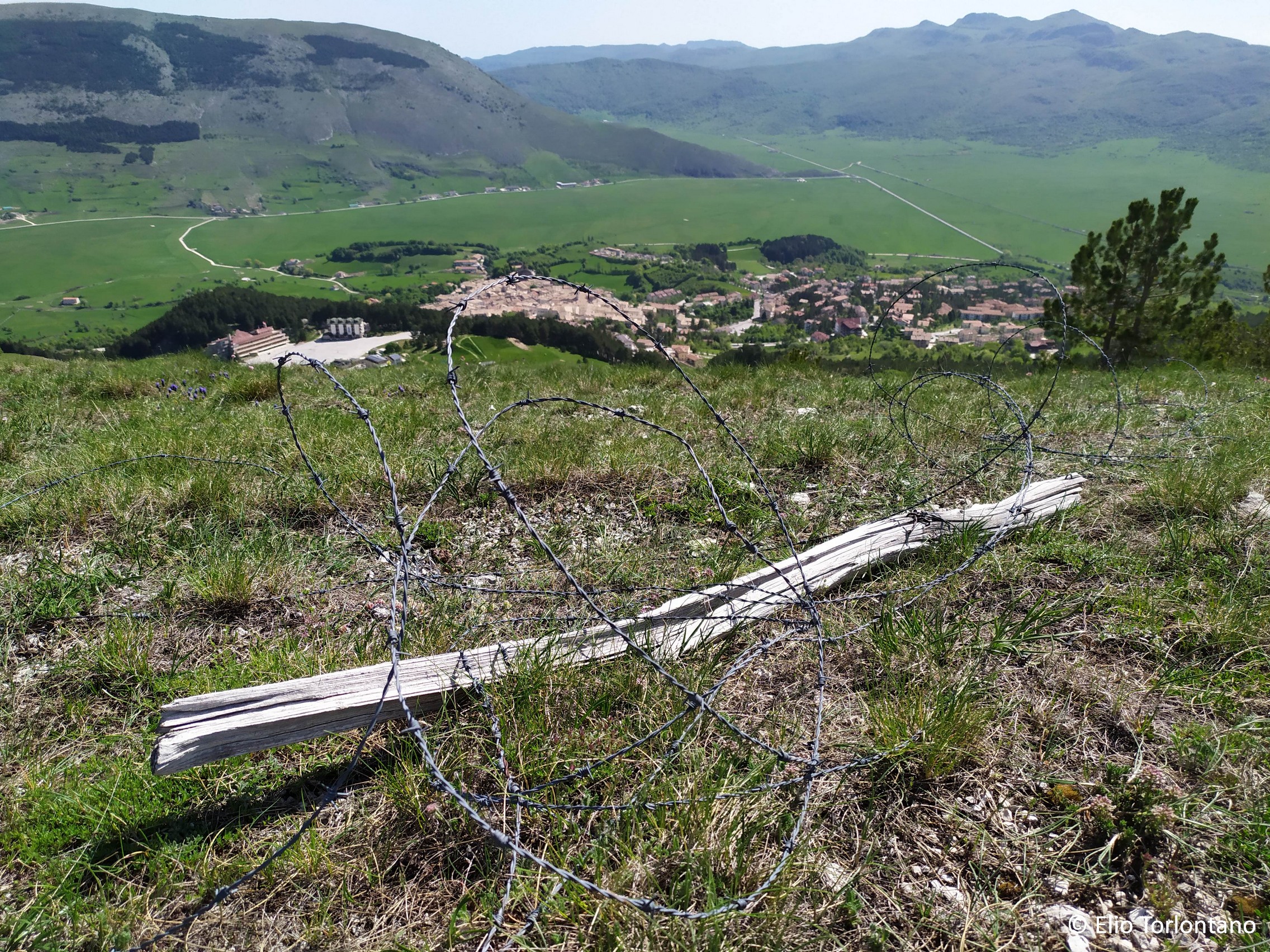 Filo di ferro spinato di una vecchia recinzione sul Monte Calvario di Pescocostanzo (sullo sfondo), un pericolo e un detrattore ambientale da eliminare.